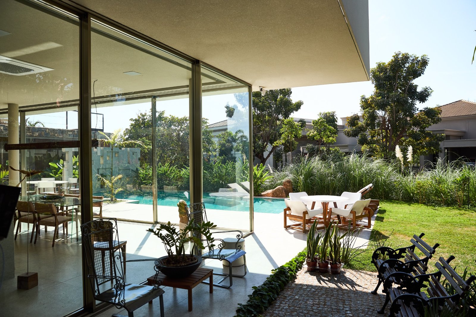 Piscina e fachada com detalhe amadeirado da Obra V+M